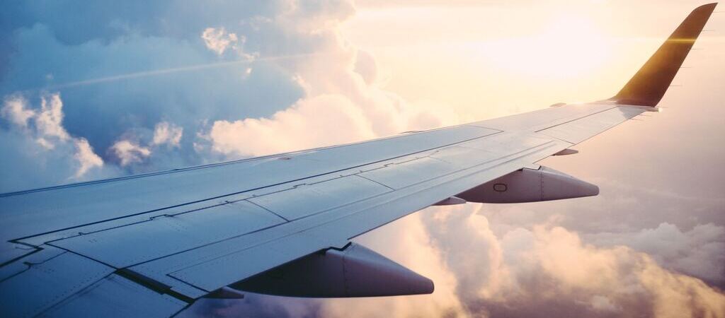 Symbolbild "Curaçao Flugzeit: Blick aus dem Flugzeug auf einen Sonnenaufgang.