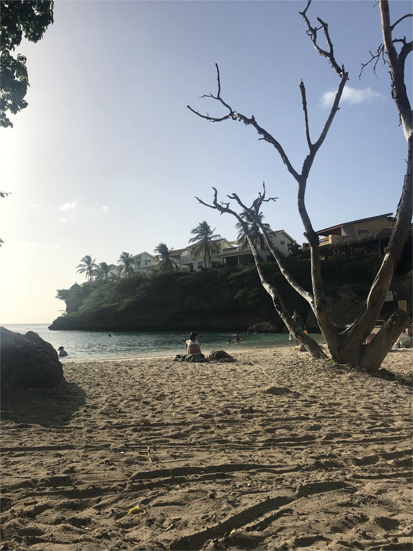 Es ist ein Sonnenuntergang mit Blick auf das Meer am Playa Lagun auf Curaçao zu sehen.