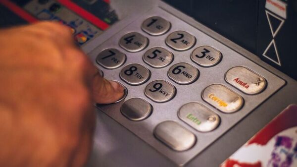 Eine Person hebt mithilfe einer Reisekreditkarte Bargeld am Bankautomaten ab