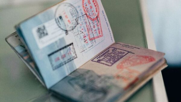 Symbolic image “Curaçao visa”: An opened passport lies on a table and is stamped with several stamps.