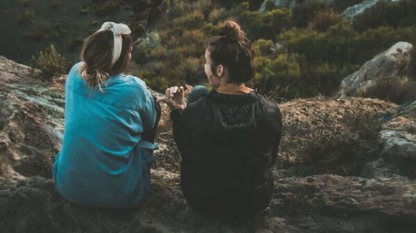 Symbolbild "Curaçao Sprachen": Zwei Frauen sitzen auf einem Berg und unterhalten sich.