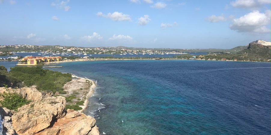 Aussicht auf den Jan Thiel auf Curaçao. Man sieht links einen Teil der Küster und rechts das blaue Meer.