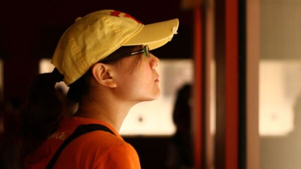 Symbolic image “Curaçao museum”: Visitor wearing a yellow cap looks around a museum.