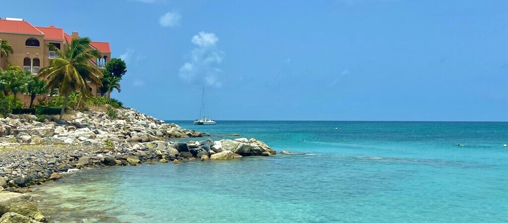 Aussicht von einer steinigen Bucht in St. Maarten, einer der Niederländischen Karbikinseln, auf den Ozean.