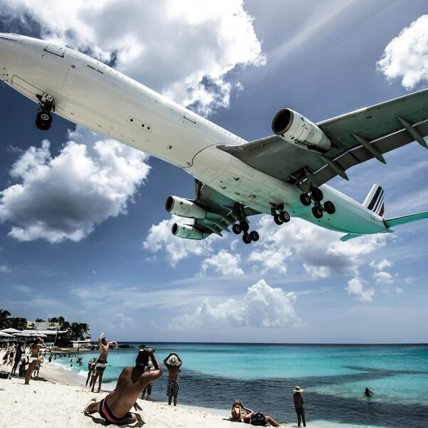 Ein Flugzeug fliegt knapp über einen Strand in St. Maarten, einer der niederländischen Karibikinseln.